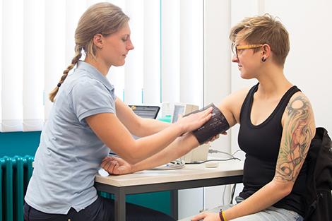 Eine Frau legt einer anderen eine Blutdruckmanschette an. Quelle: © Edgar Zippel