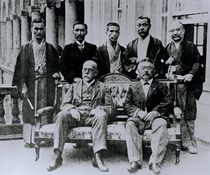 Koch und Kitasato sitzen auf einem Sofa, hinter ihnen stehen japanische Institutsmitarbeiter. (© Archiv der Humboldt-Universität zu Berlin) Koch und Kitasato sitzen auf einem Sofa, hinter ihnen stehen japanische Institutsmitarbeiter.